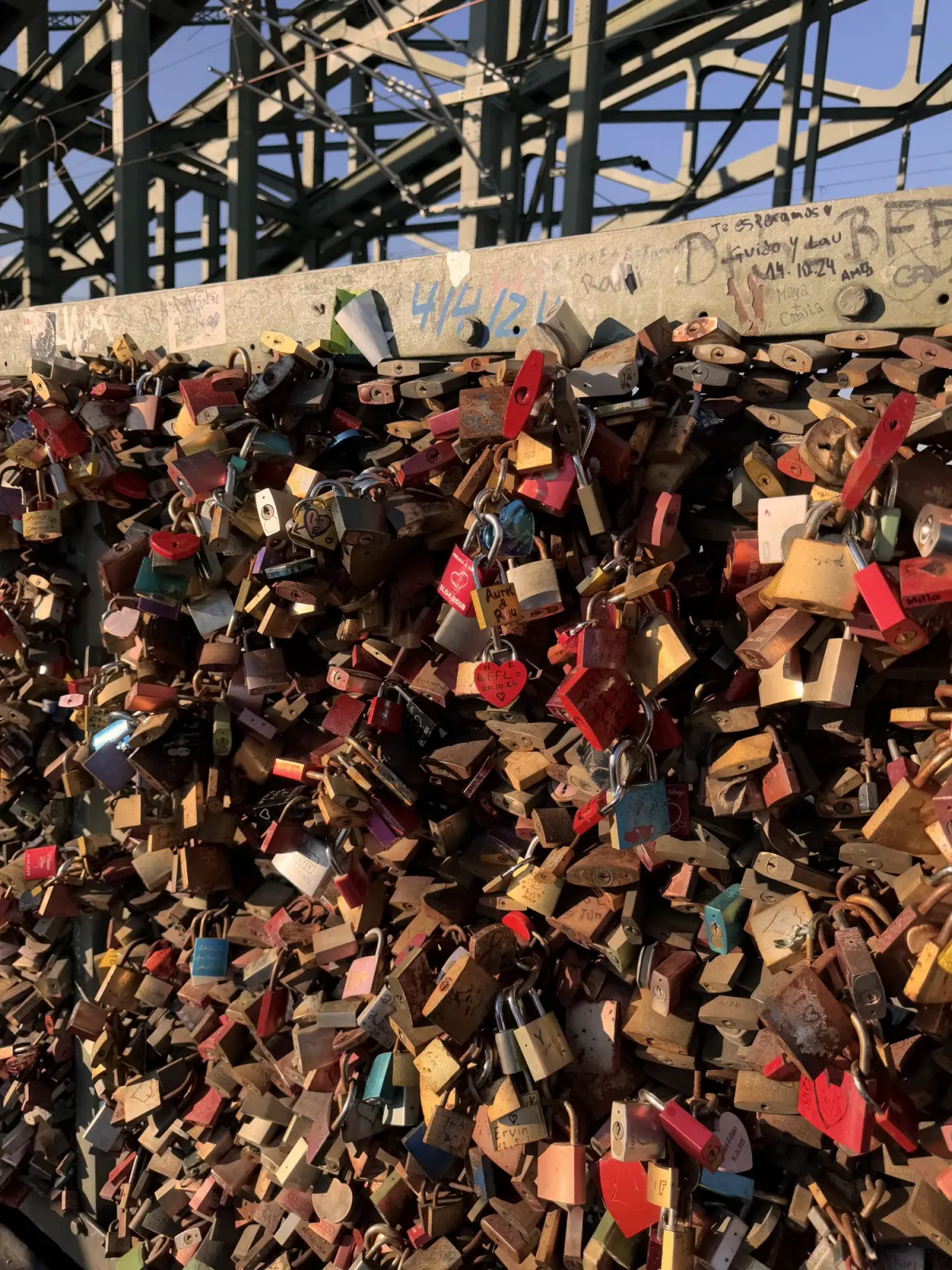 Love locks on the railing of the Hohenzollern Bridge in Cologne, under the steel arches